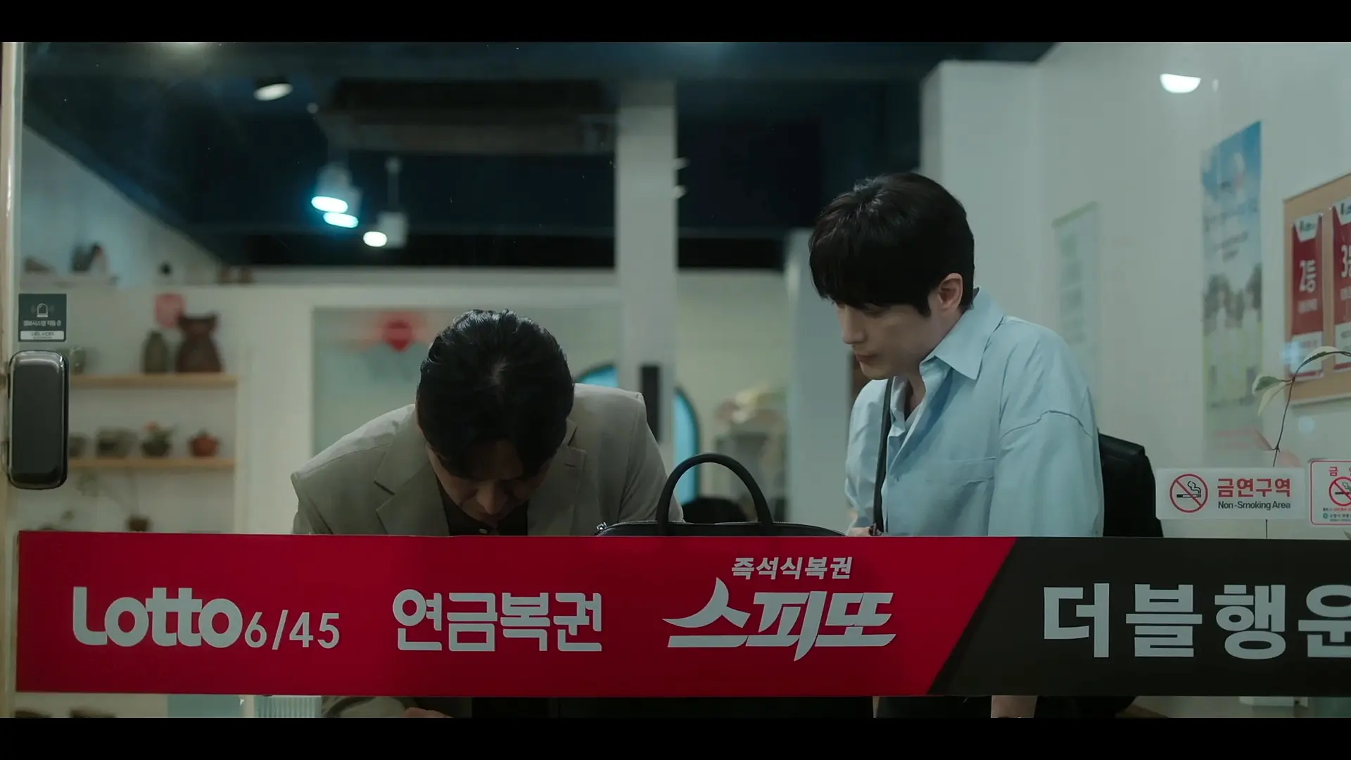 Team Leader Seon-hyeok and Eun-tae examining numbers in Episode 5 of The Ordinary Jackpot