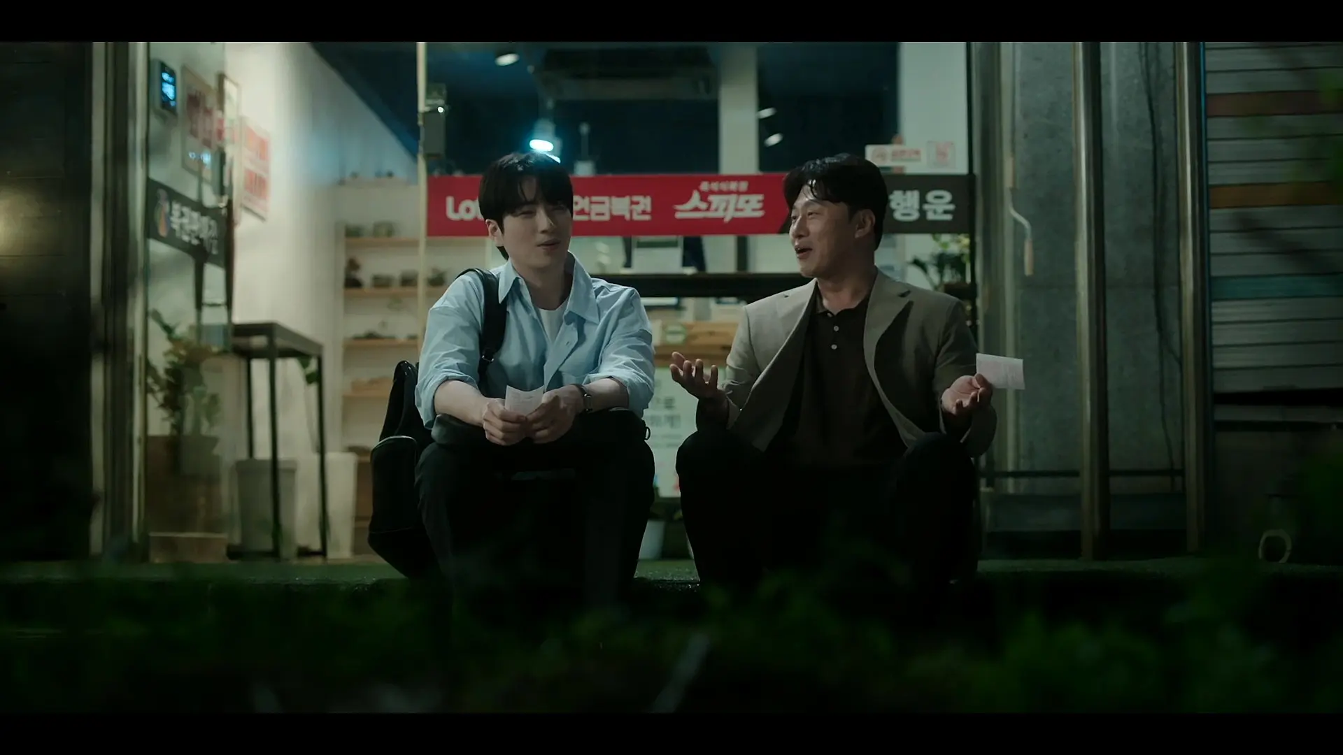Seon-hyeok and Eun-tae sharing a laugh outside the lottery shop in Episode 5