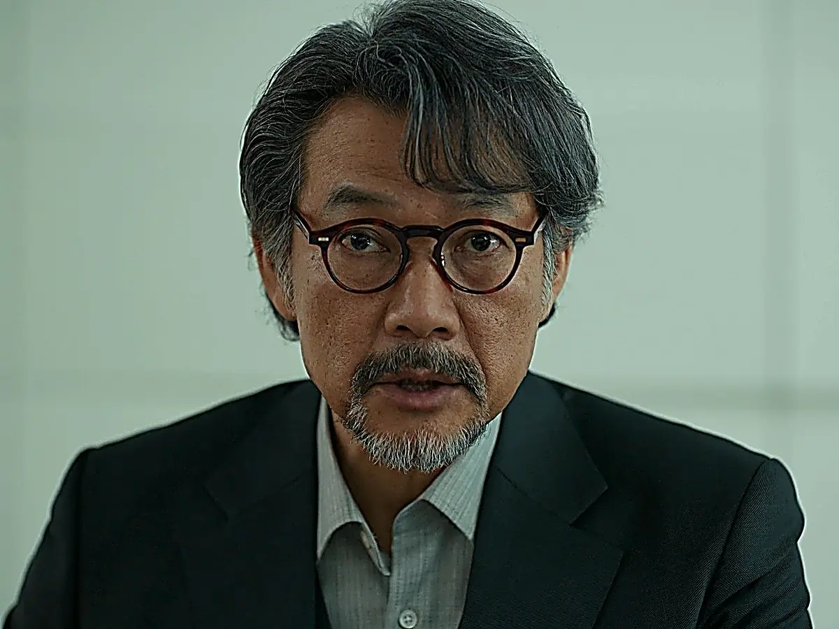 Kang Seung-woon wearing a charcoal tailored suit jacket and collared shirt in Four Hands episode 11