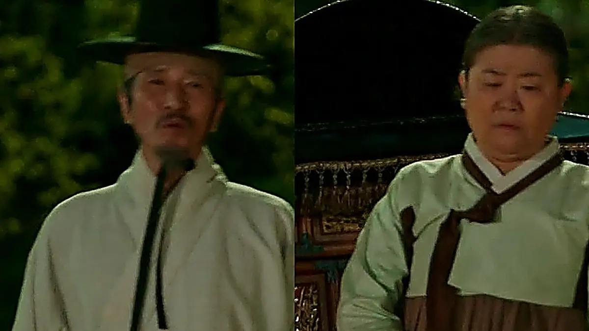 A man in a traditional hat and coat standing beside a woman and palanquin at night