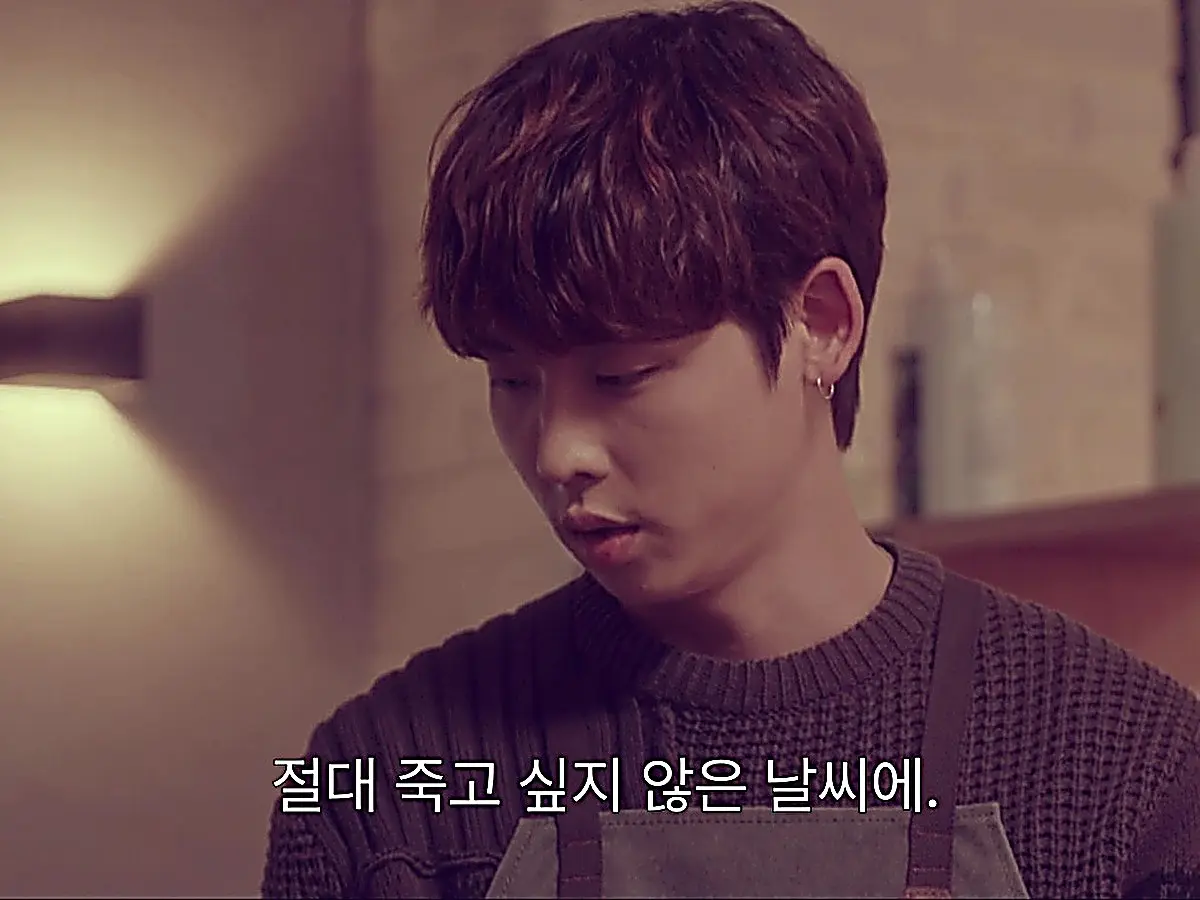 Park Mu-yeol wearing a dark waffle knit crewneck sweater beneath a salon work apron