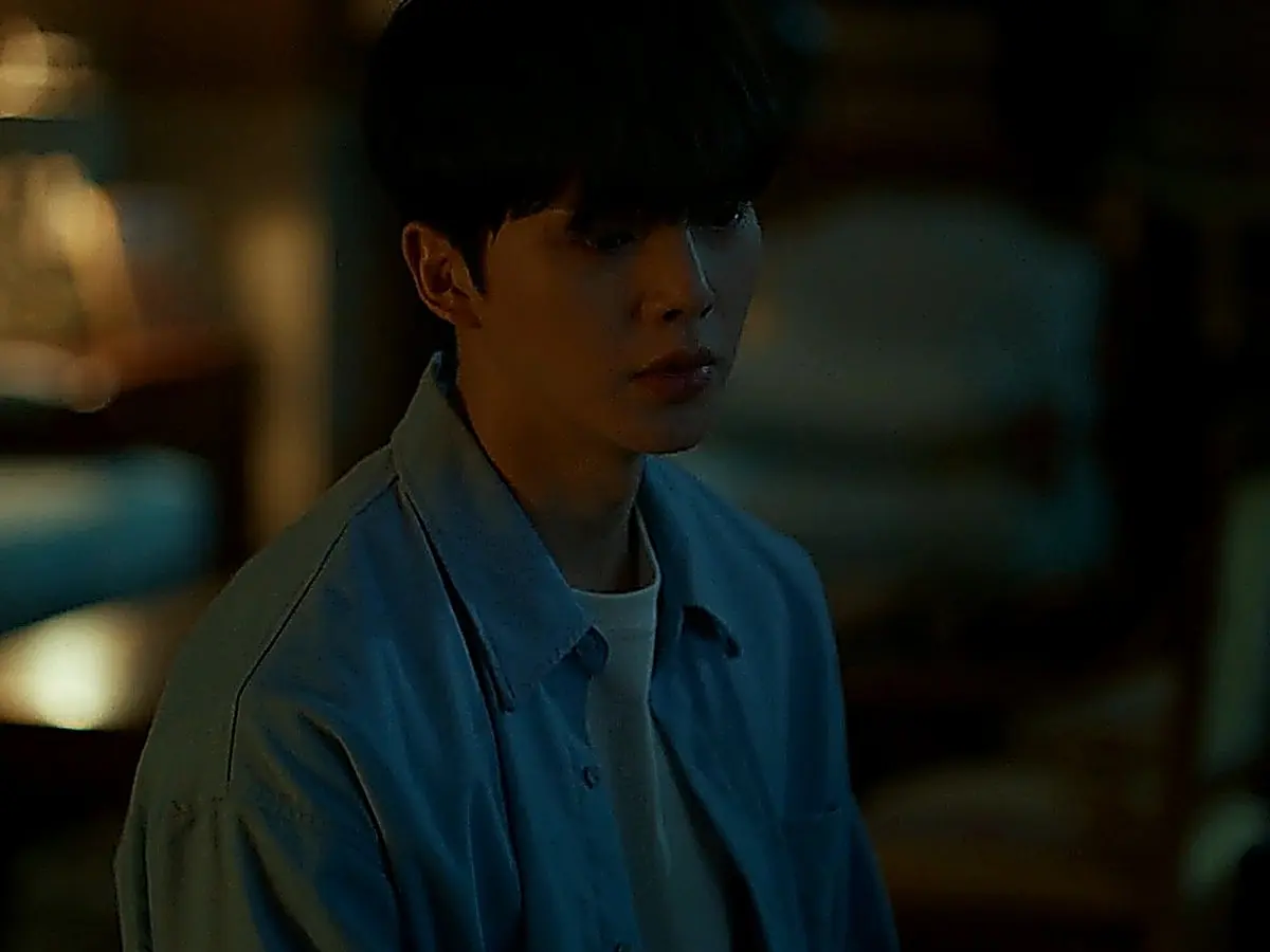 Kang Bi-o dressed in an unbuttoned light blue cotton shirt layered over a white crewneck tee