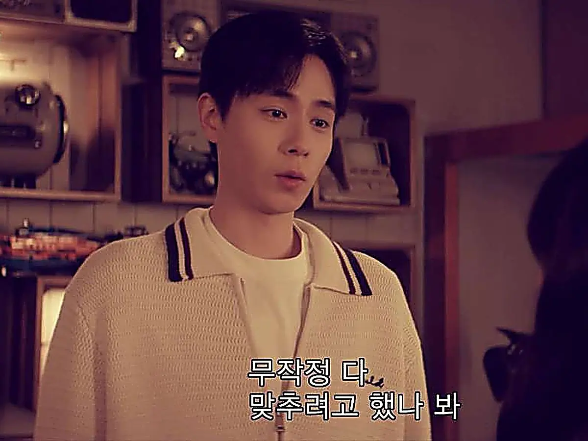 Jiang Yubai wearing a light knit polo sweater with dark tipped collar over a crewneck tee