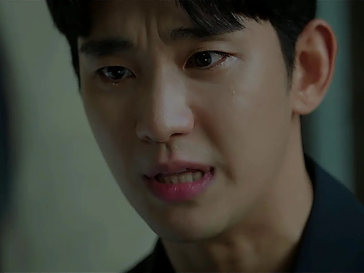 Baek Hyun-woo in a dark navy tailored blazer over a dark top