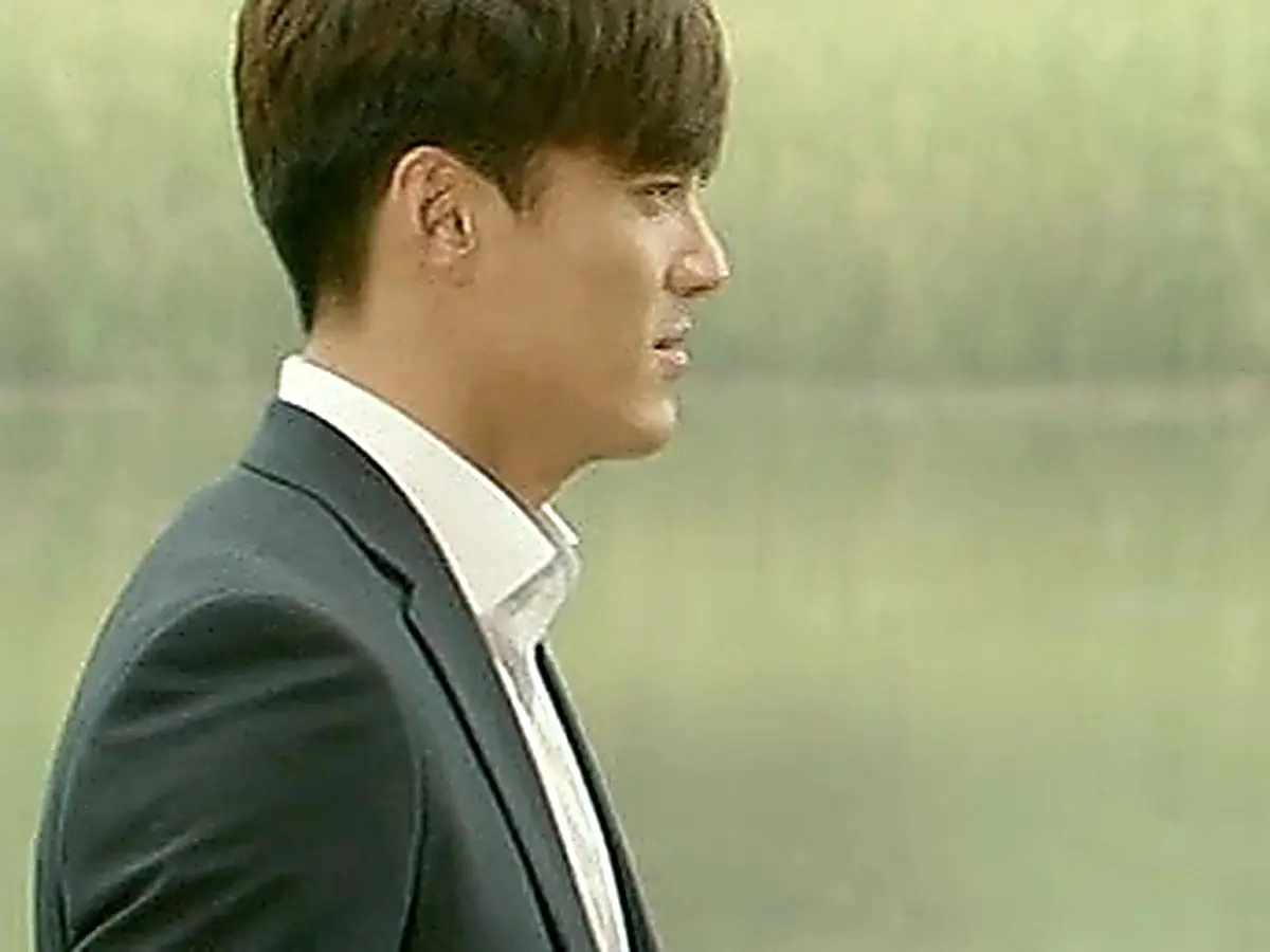 Han Tae-jin wearing a dark tailored suit blazer and crisp white shirt