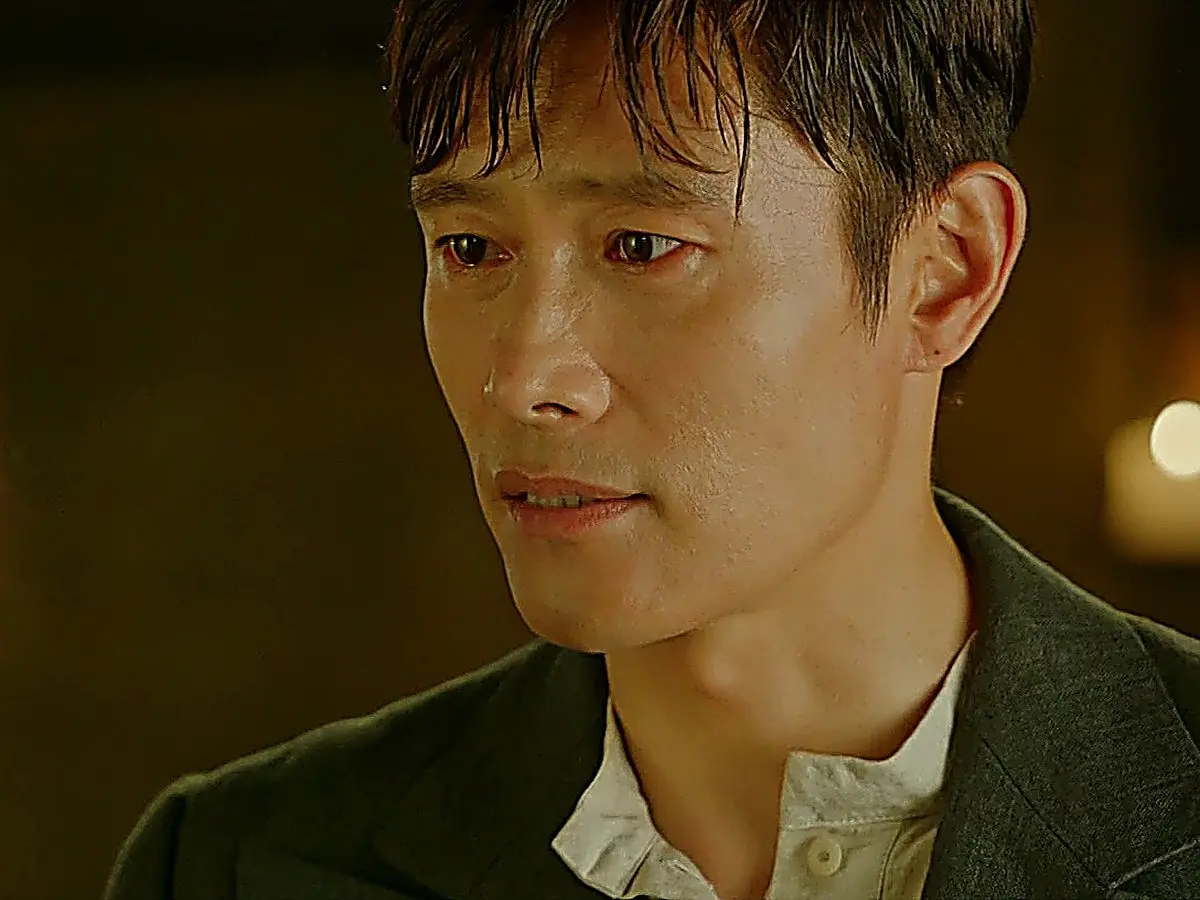 A man in a dark jacket looking ahead with tearful eyes