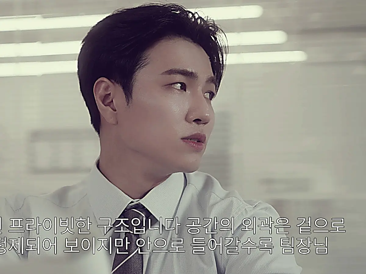 Lee Seon-woo presenting the VIP lounge design concept in a light blue dress shirt and patterned tie