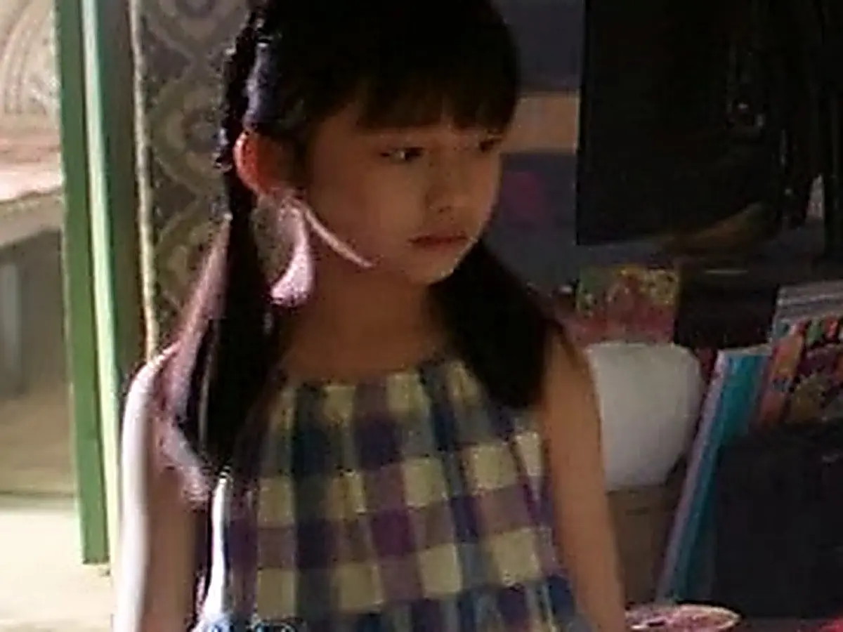 Jin Zhao wearing a black ribbed tank top indoors