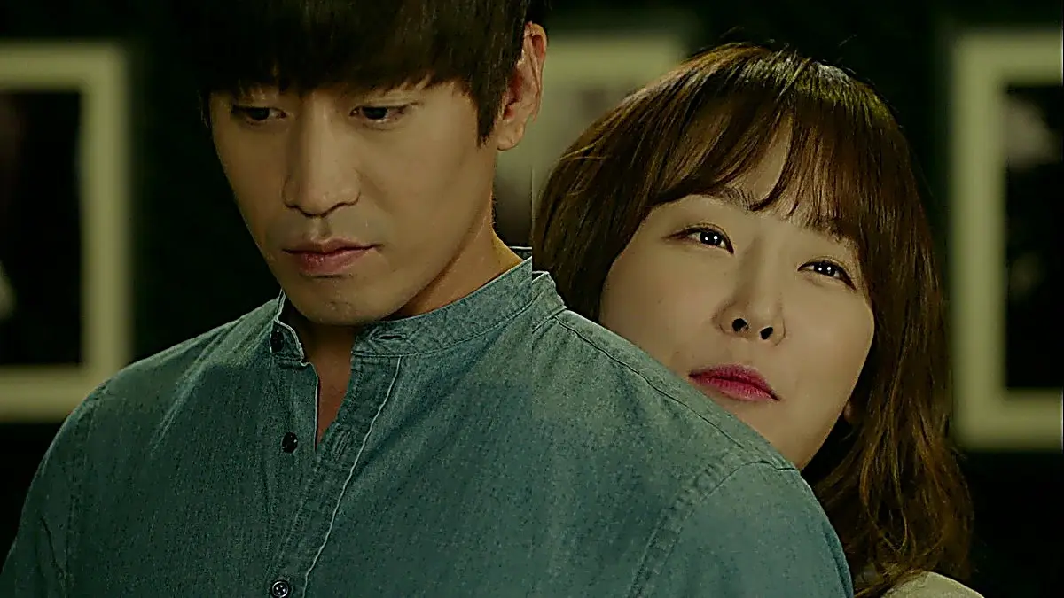 Oh Hae-young leaning against Park Do-kyung while he wears a teal band-collar shirt
