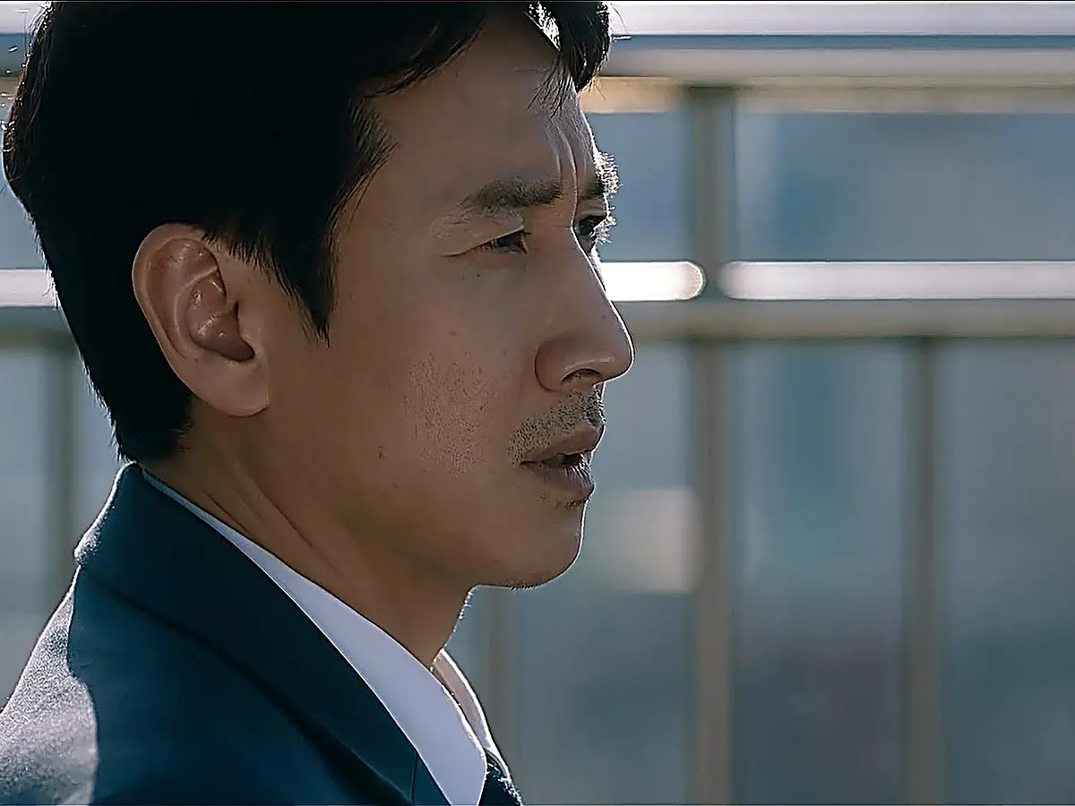 Close-up profile of a man in a dark suit looking ahead