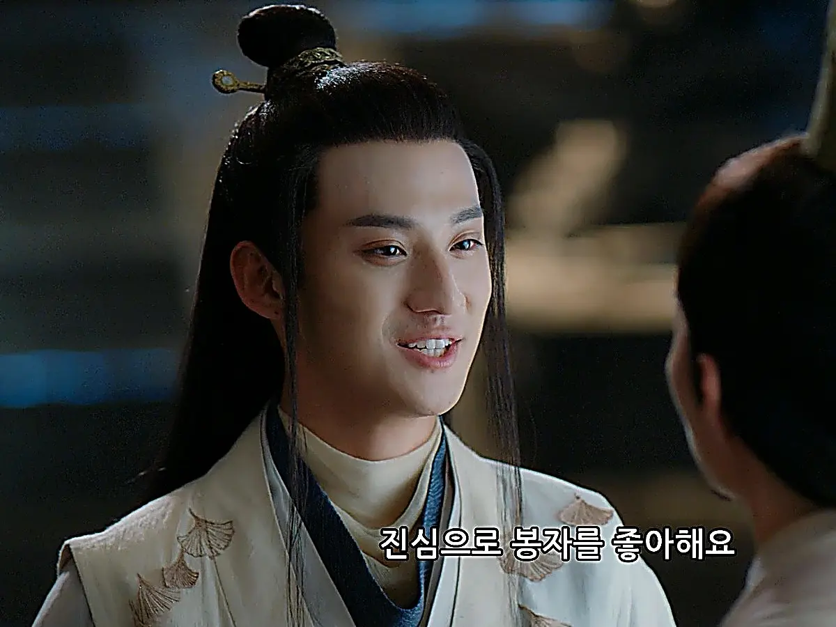 A smiling young man in a white and blue patterned robe facing an older man