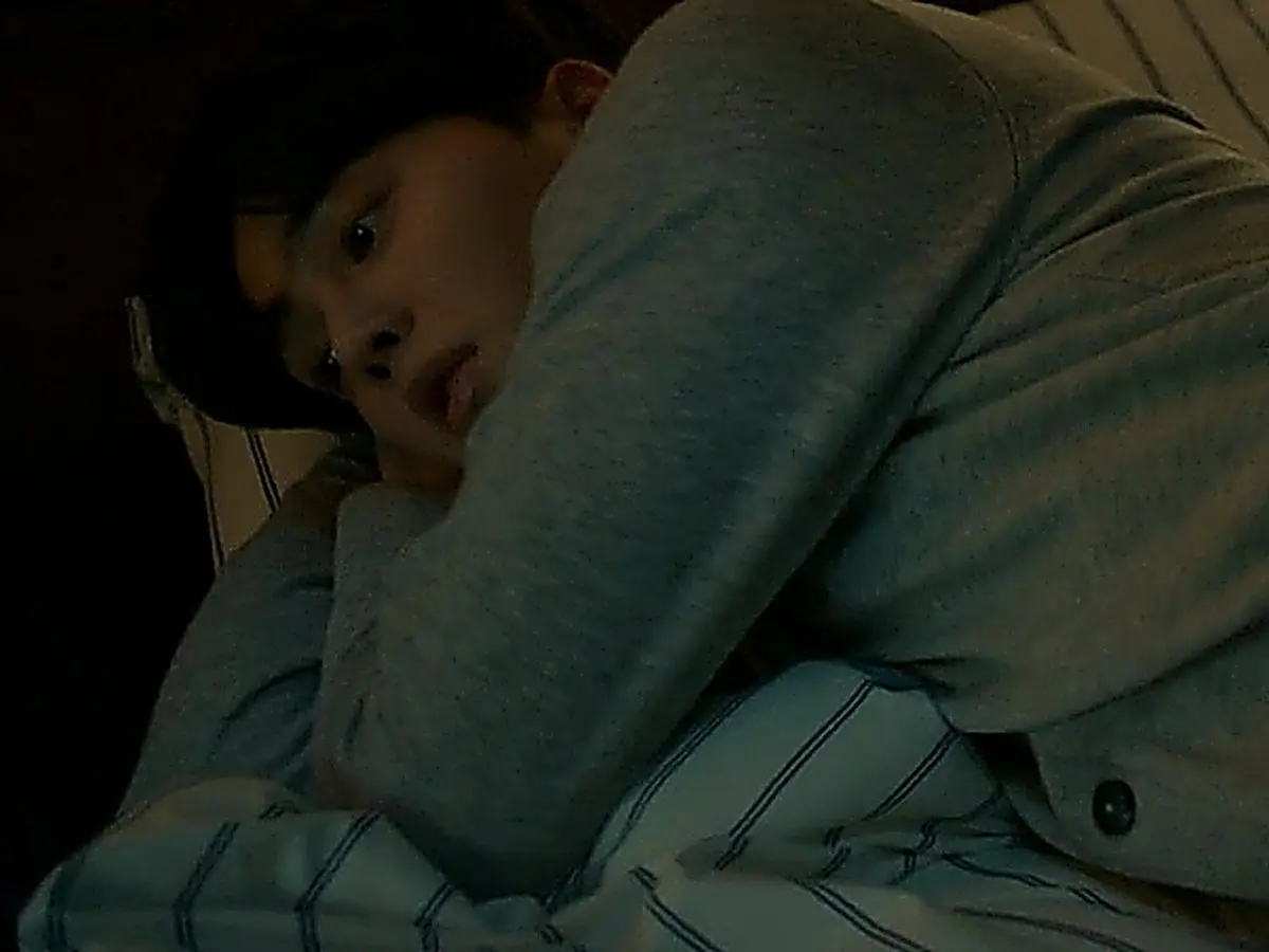 Kang Bi-o resting in a heather grey long-sleeve knit top with ribbed cuffs