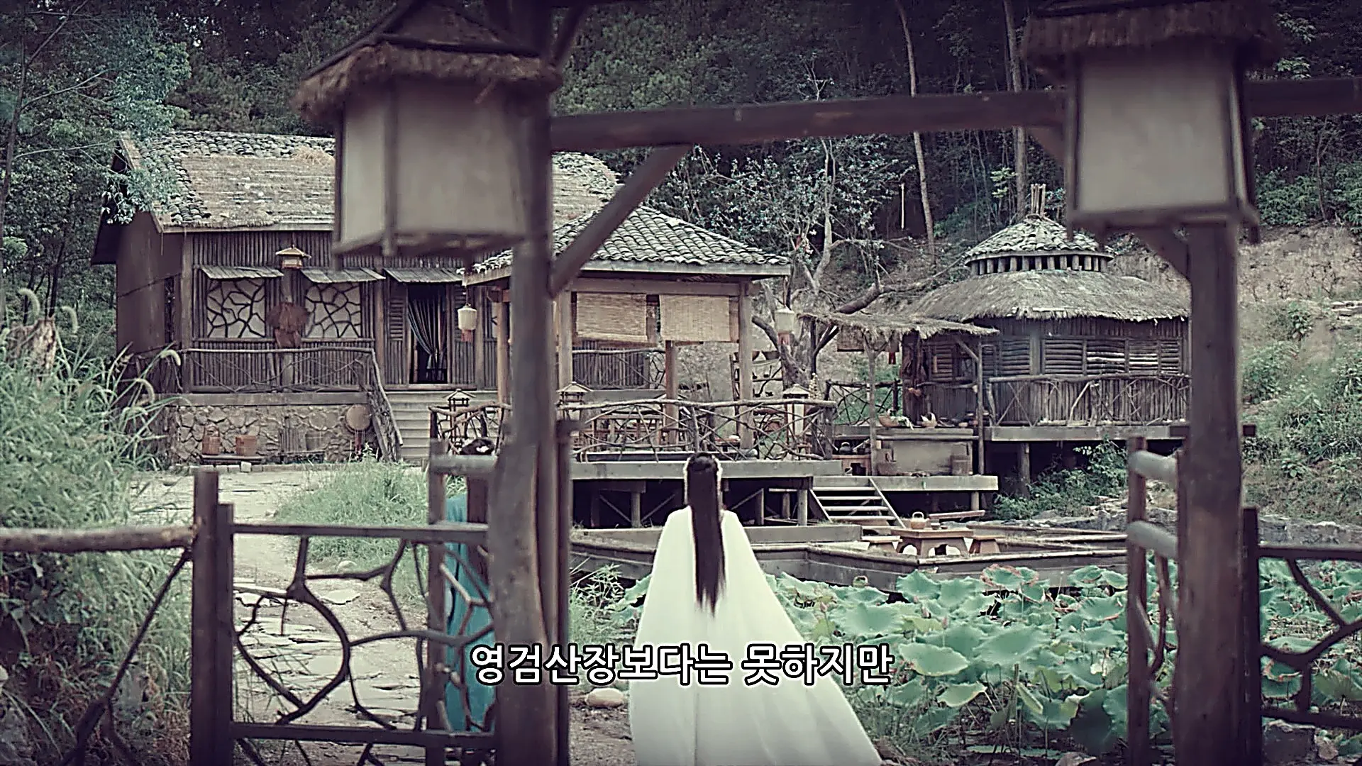 Lin Fengzi's modest wooden shelter framed by forest greenery