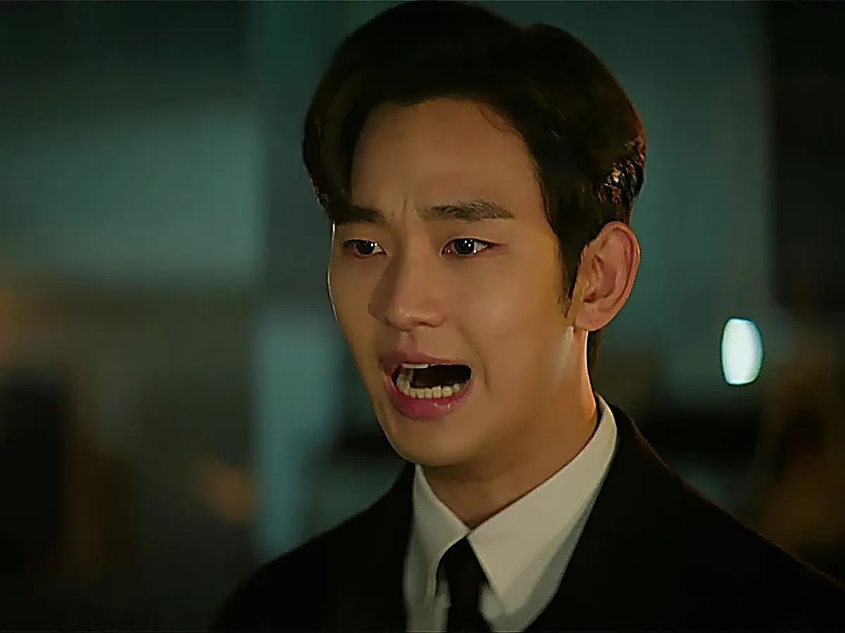 Close-up of a man in a dark suit shouting with an alarmed facial expression