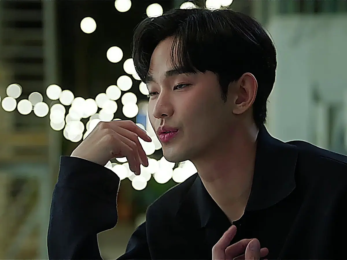 Baek Hyun-woo wearing a dark open-collar knit shirt during an evening scene