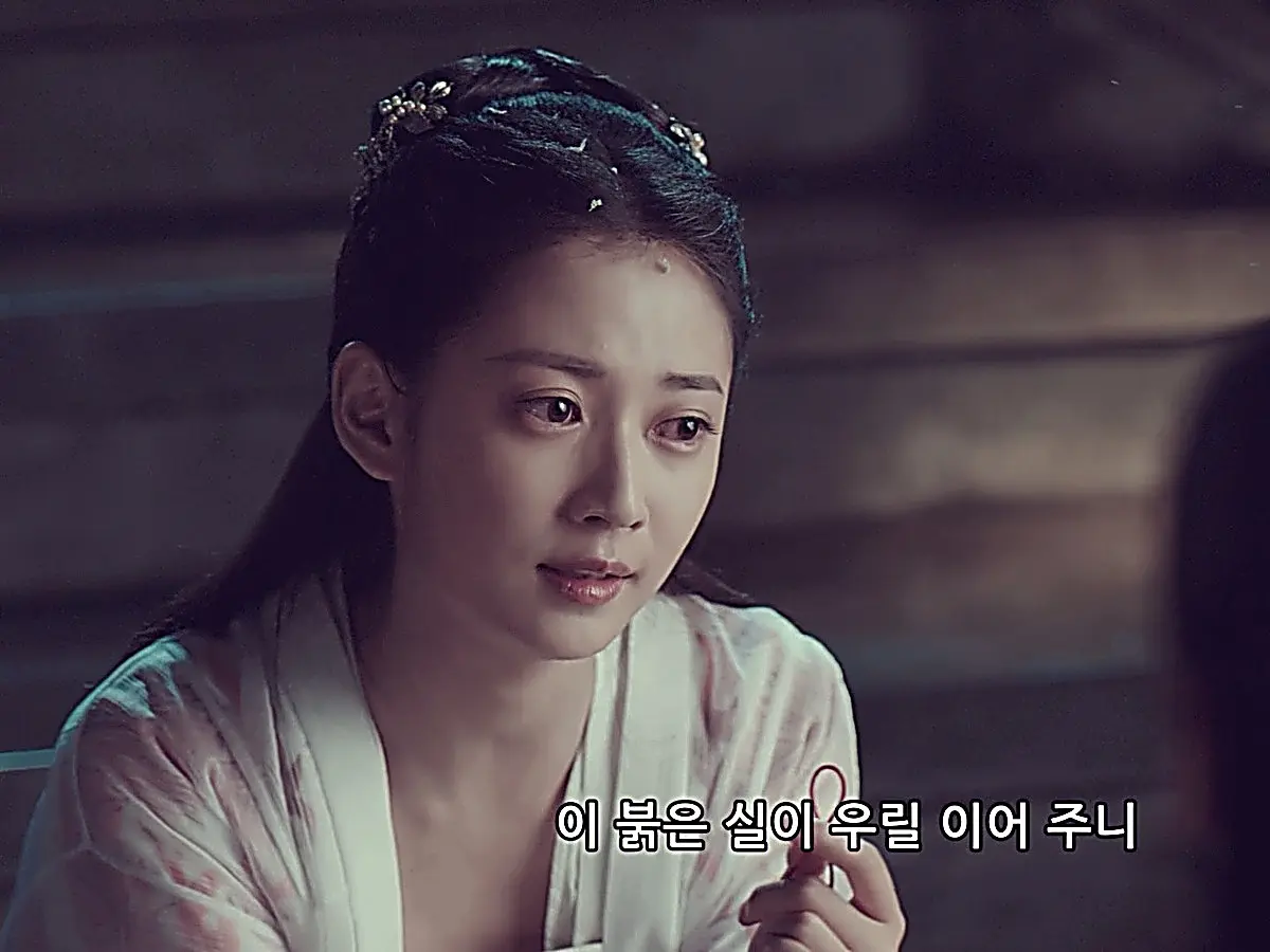 Chong Xuezhi holding up the red string tied to her wrist