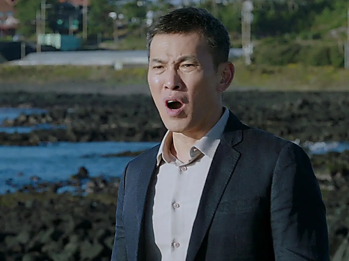 Dark tailored suit blazer and collared dress shirt on the rocky coast