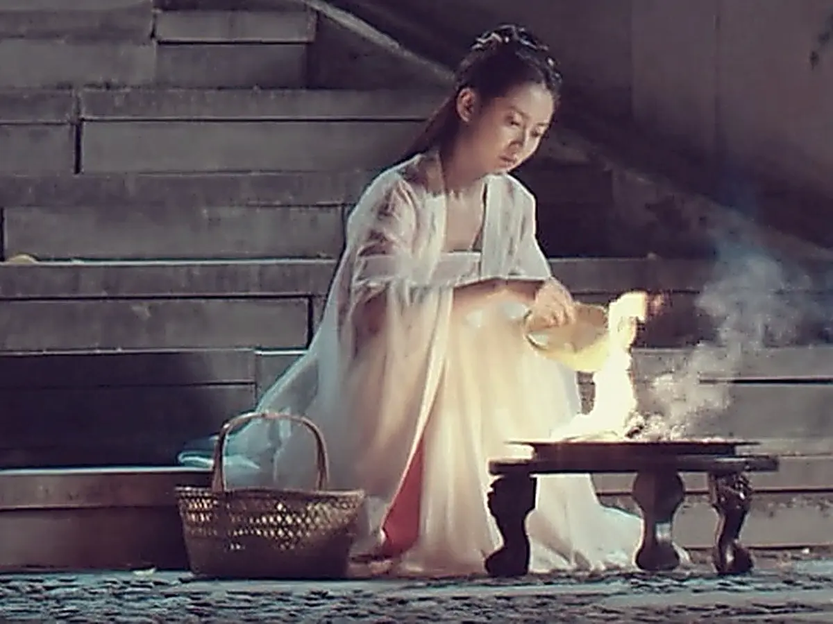 Chong Xuezhi burning paper money under the bridge in white mourning attire