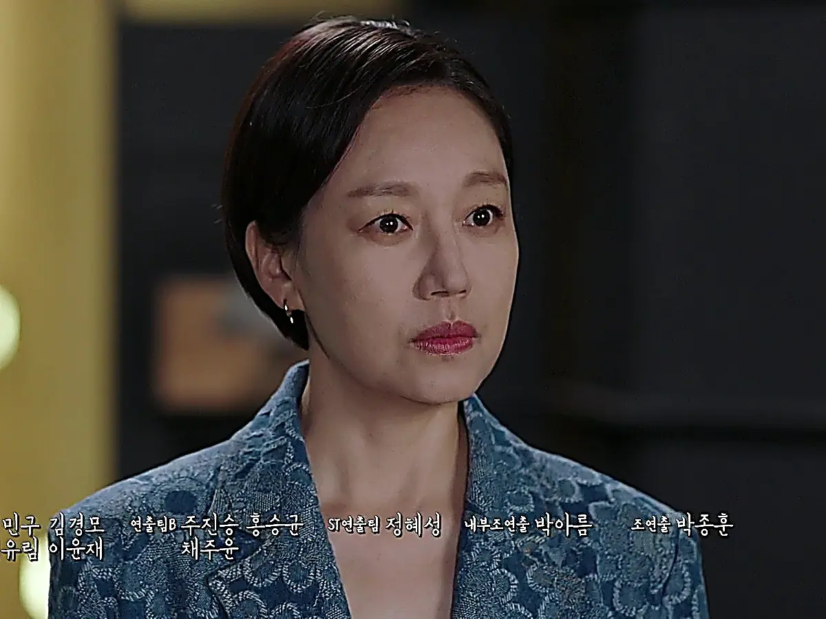 Hong Ok-seon wearing a structured teal textured jacquard blazer with notch lapels