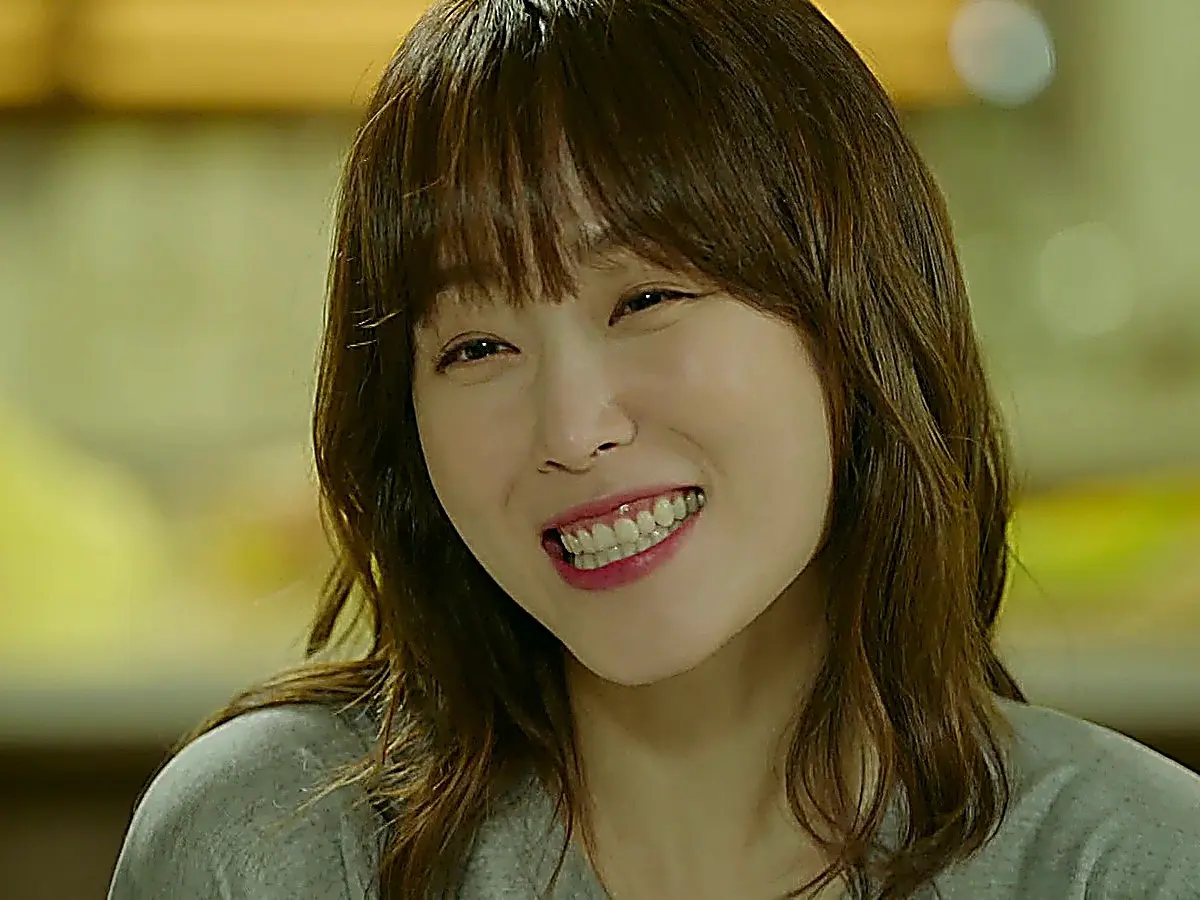 Oh Hae-young grinning in a heather grey crewneck t-shirt