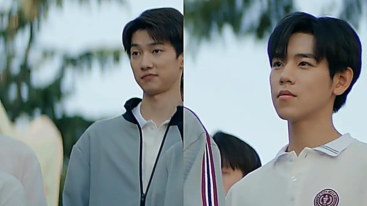 Lin Zhixia and Zhang Yubai standing side by side in matching grey track jackets with navy and crimson sleeve stripes and white polo shirts