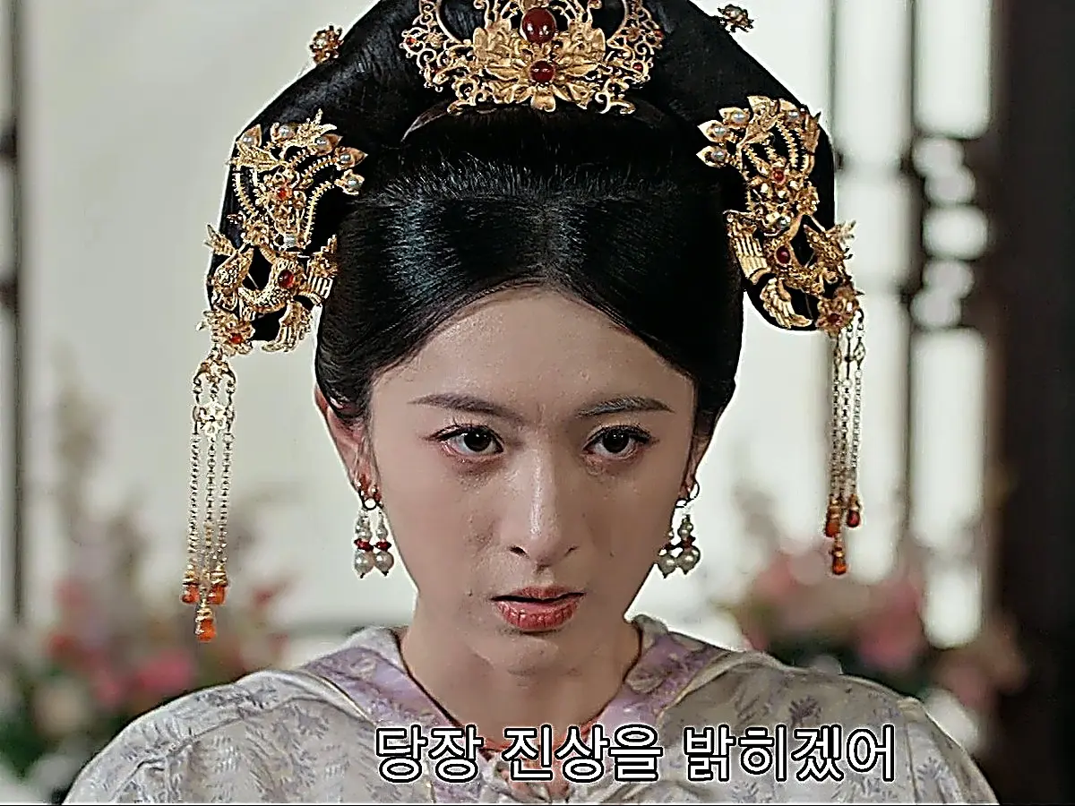 Concubine Duan wearing a high winged headpiece adorned with gold filigree and dangling coral tassel pendants