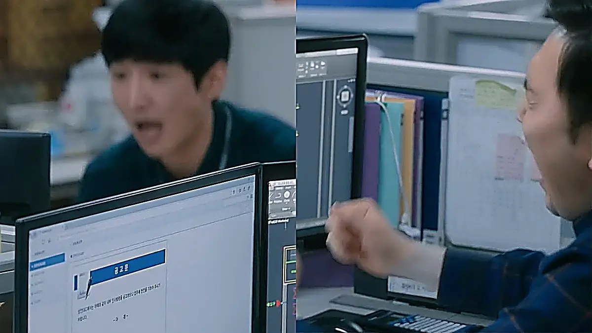 Two office workers reacting with raised fists before computer monitors