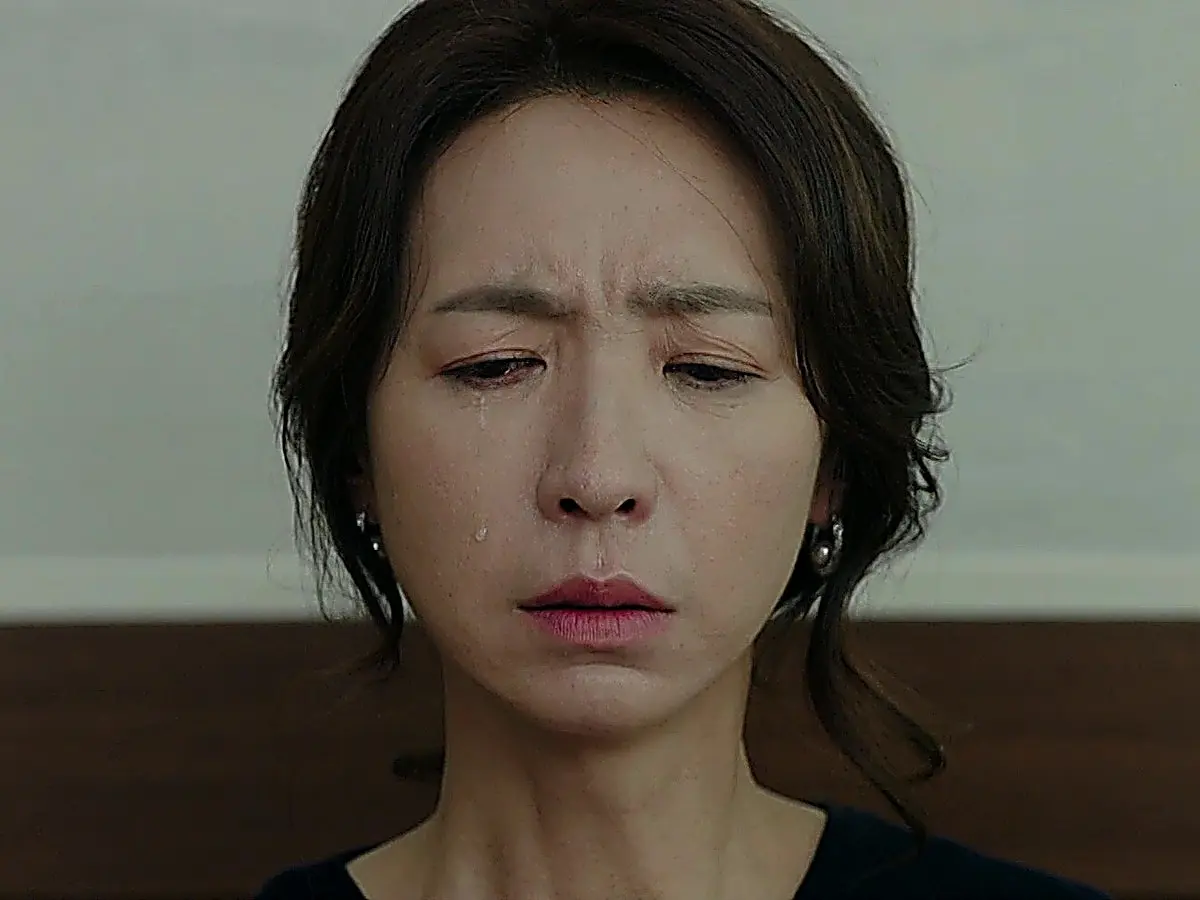 Close-up portrait of a woman looking downward with tears on her face
