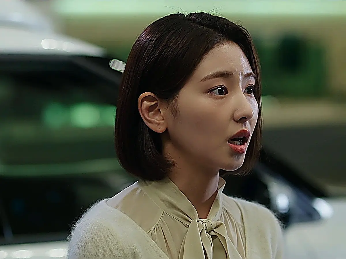Lee Ji-hye wearing a cream knit cardigan over an ivory bow-tie blouse