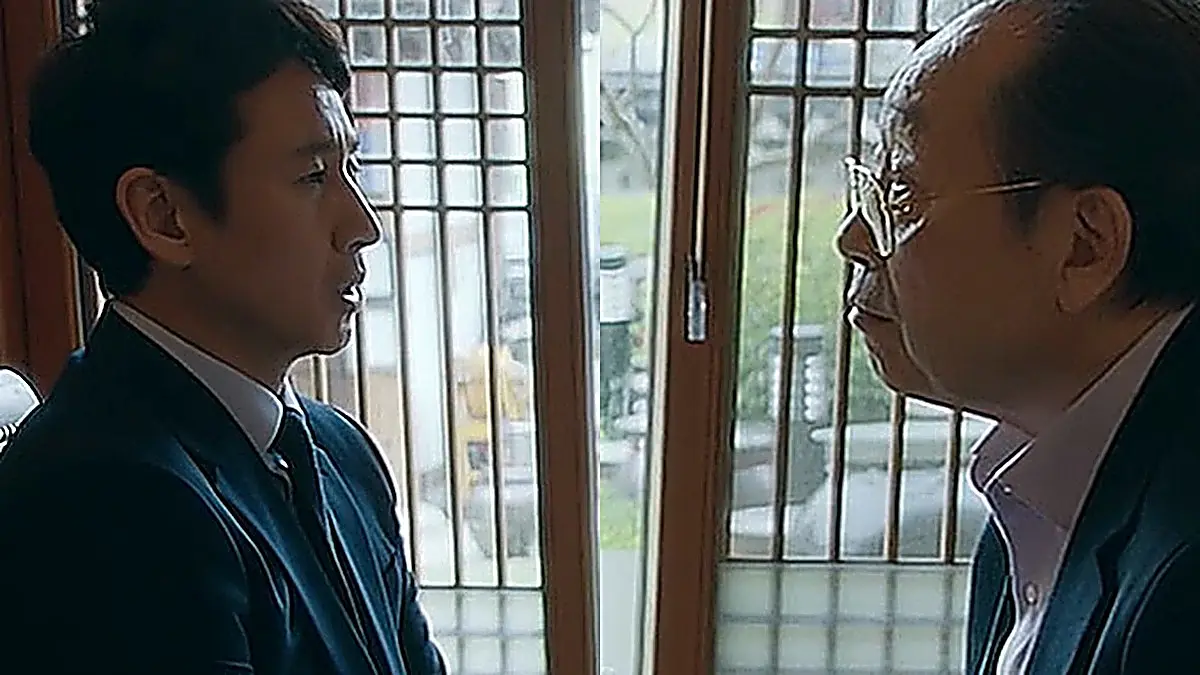 Park Dong-hoon in a dark suit opposite Chairman Jang in a tailored jacket and collared shirt