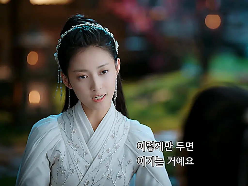 A woman in an embroidered white gown smiling during a board game