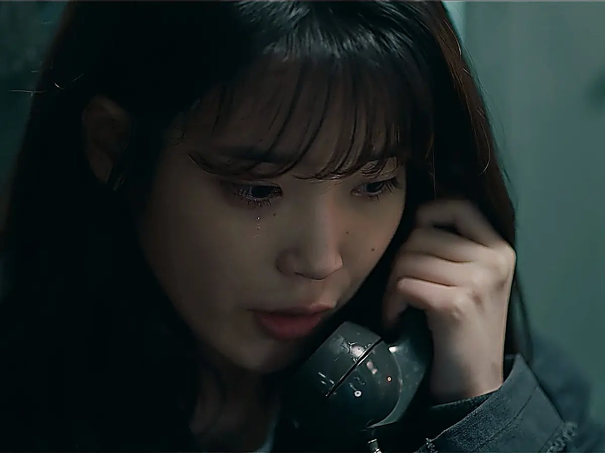 Close-up of a tearful woman holding a telephone receiver
