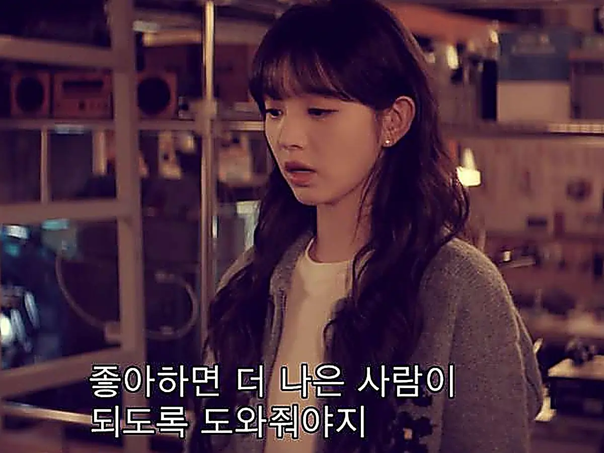 Lin Zhixia wearing a heather grey knit cardigan over a white top