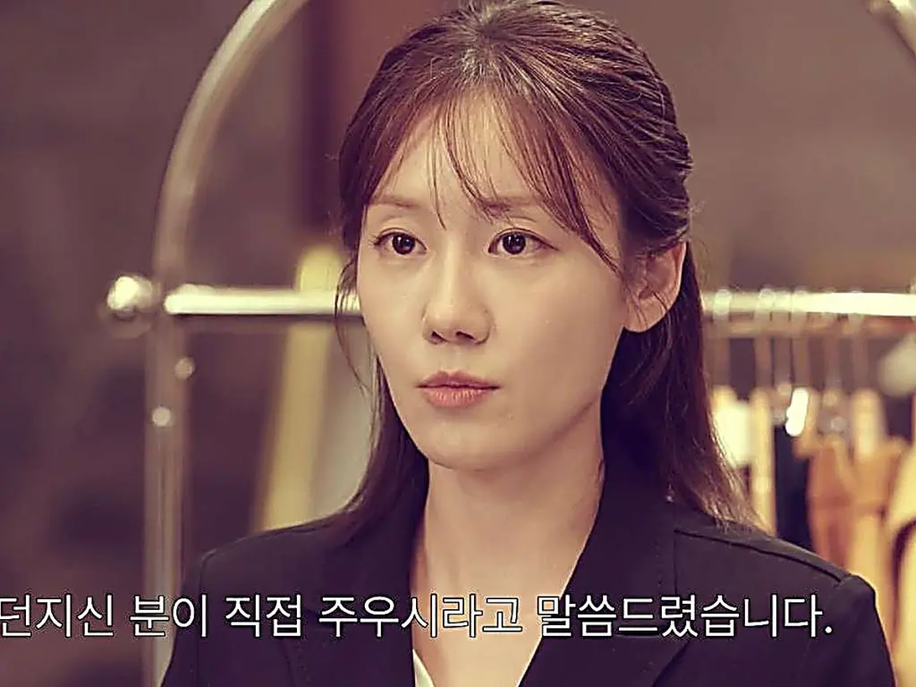 A woman with bangs in a dark blazer facing forward with a steady expression