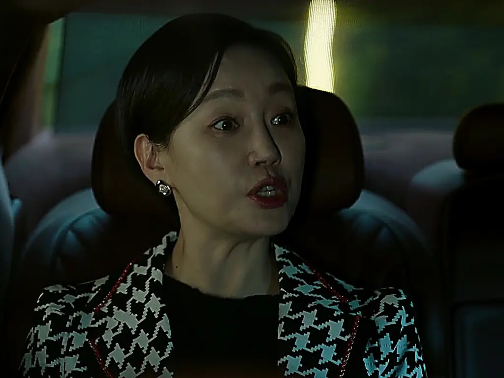 Hong Ok-seon glaring out her car window at her son's restaurant