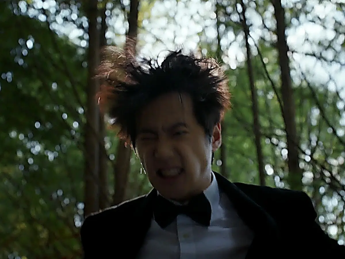 Choi Jeong-yo in a fitted black tuxedo blazer, white formal shirt, and black bow tie