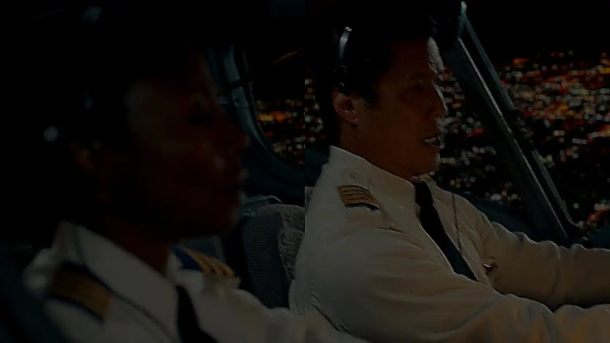 Airline pilots seated in the cockpit wearing white button-down uniform shirts with shoulder epaulets and neckties