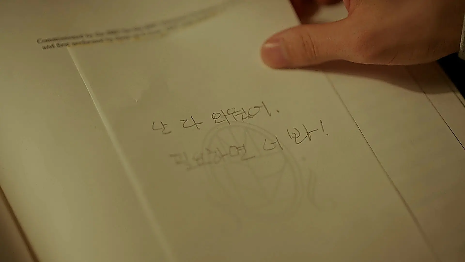Hand holding an open sheet music page with handwritten Korean notes
