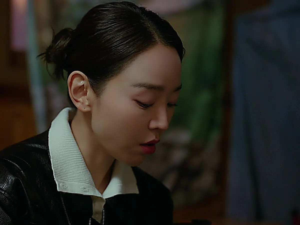 Cho Sam-dal wearing a black jacket with a white ribbed knit spread collar