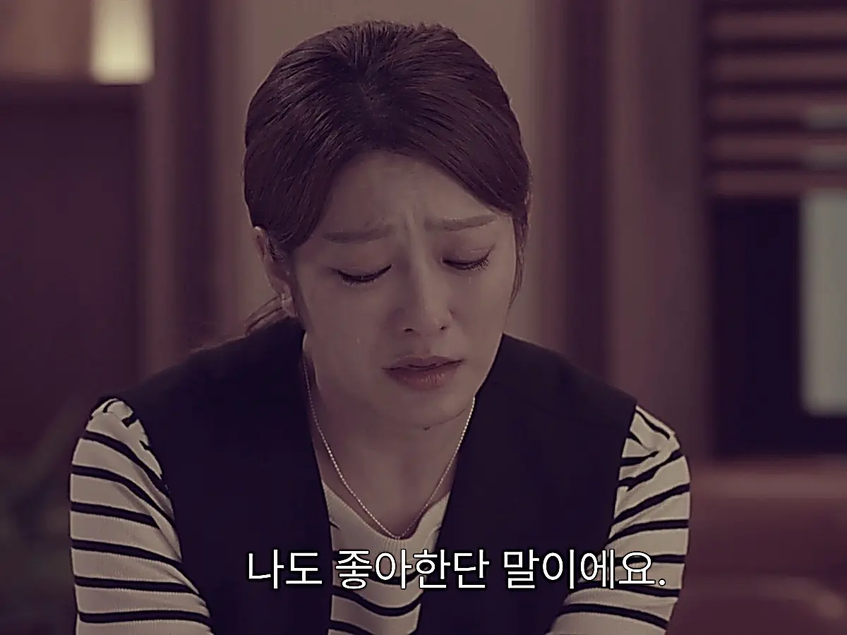 Na Ji-ni wearing a layered dark vest over a horizontal striped top