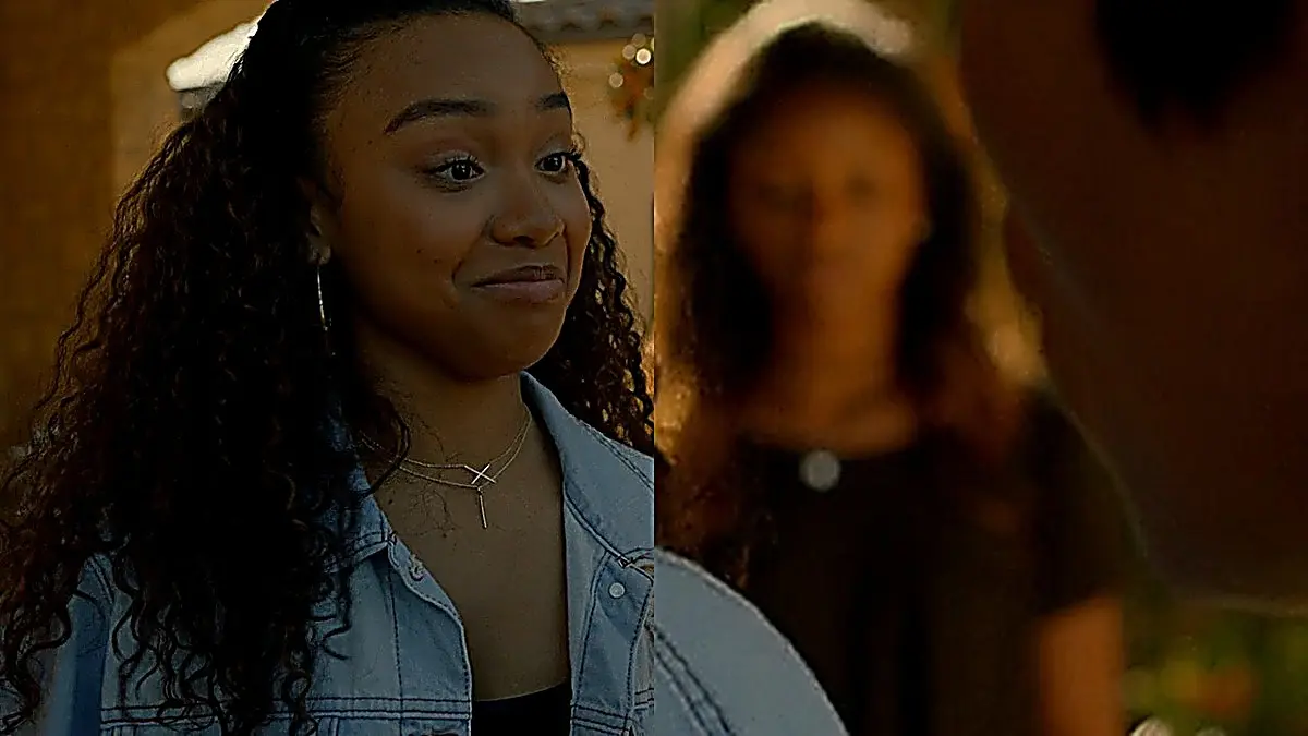 Laila wearing an oversized light-wash distressed denim trucker jacket over a black top with layered jewelry