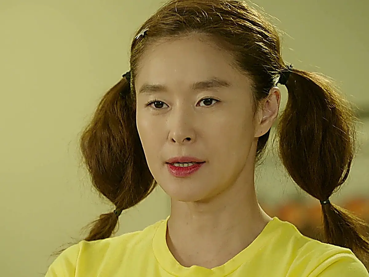 Medium portrait of a woman with pigtails wearing a yellow crew-neck shirt