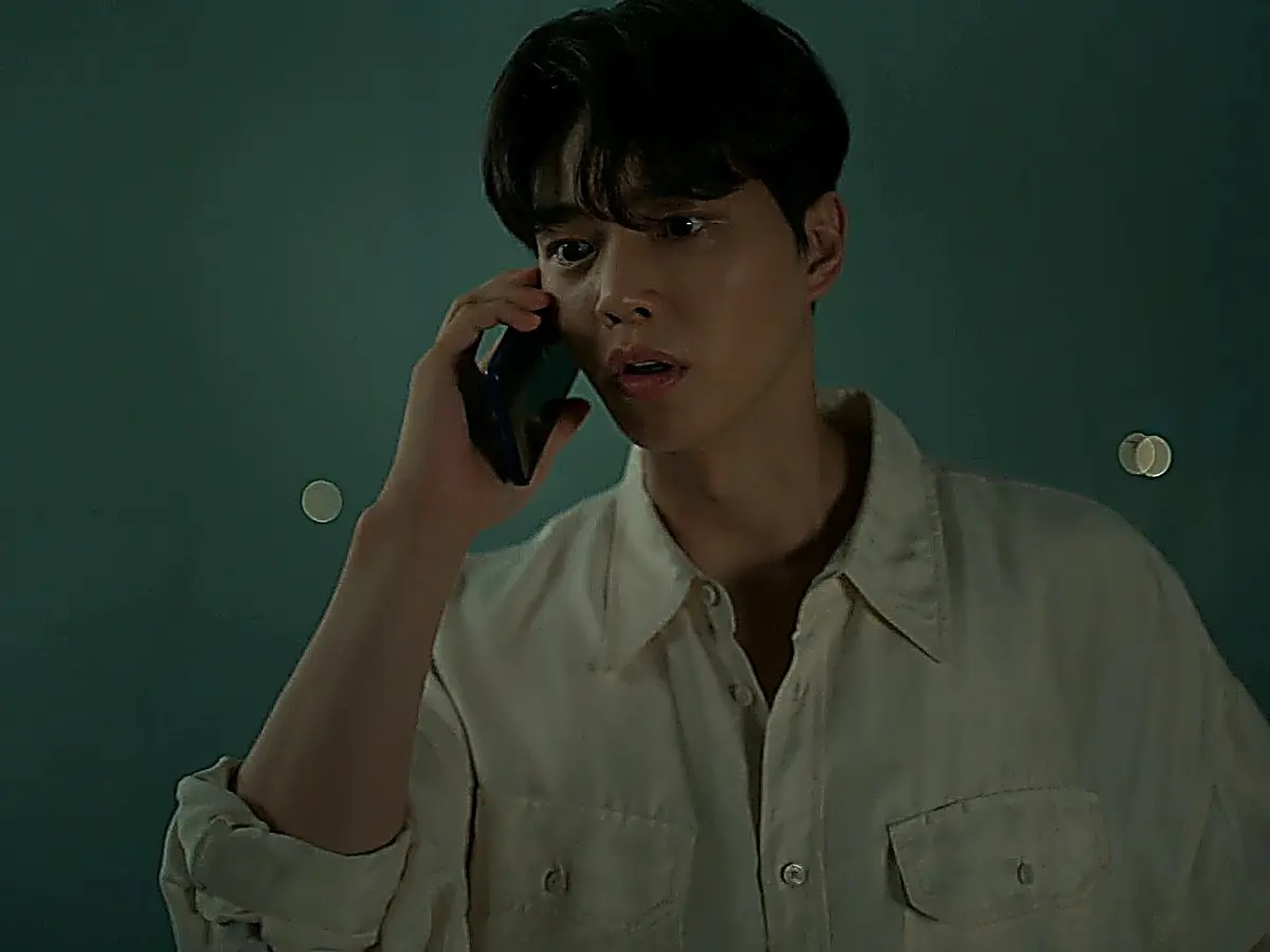 Kang Bi-o wearing a light beige collared utility shirt with flap chest pockets