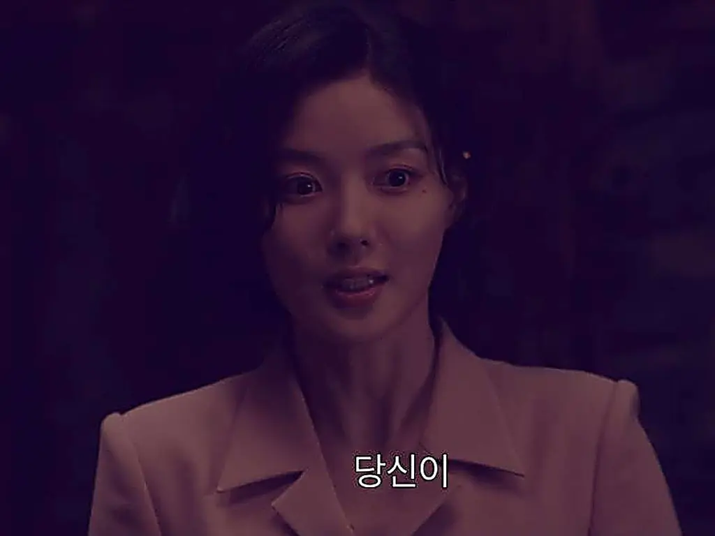 Woman with short dark hair wearing a blush pink tailored jacket with wide lapels