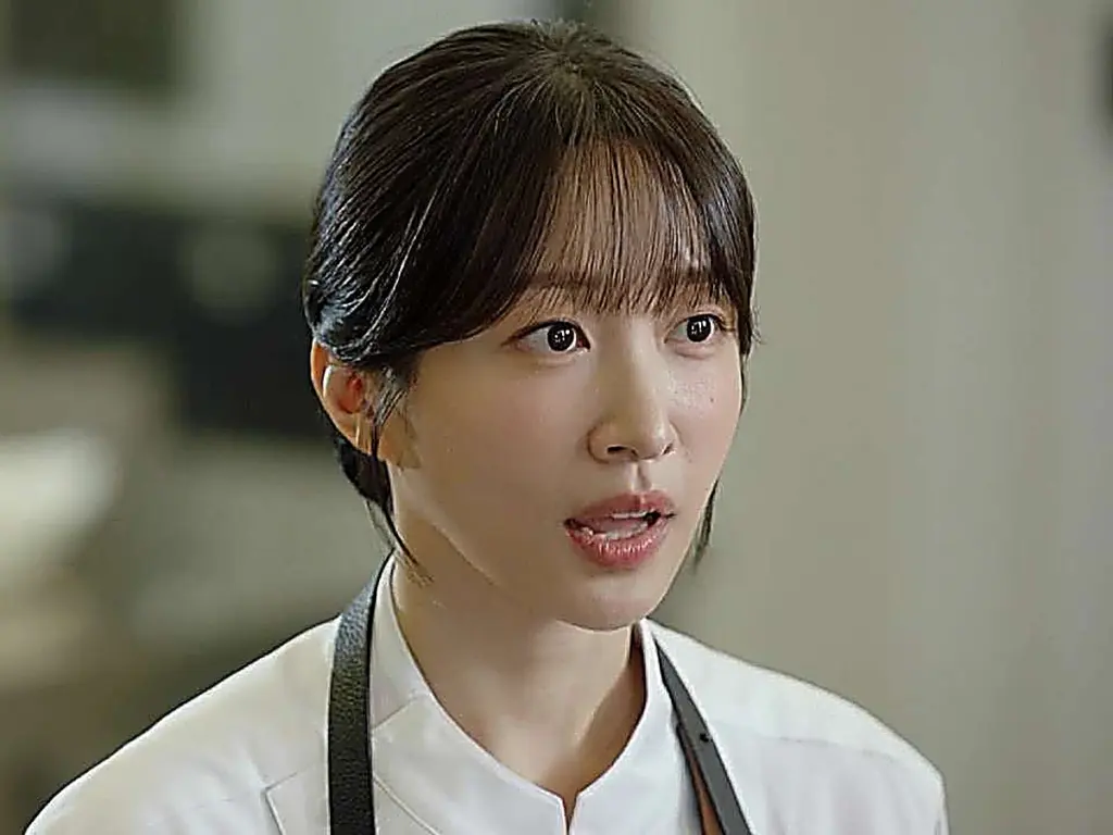 Han Gyu-rim wearing a white chef uniform jacket with black apron straps