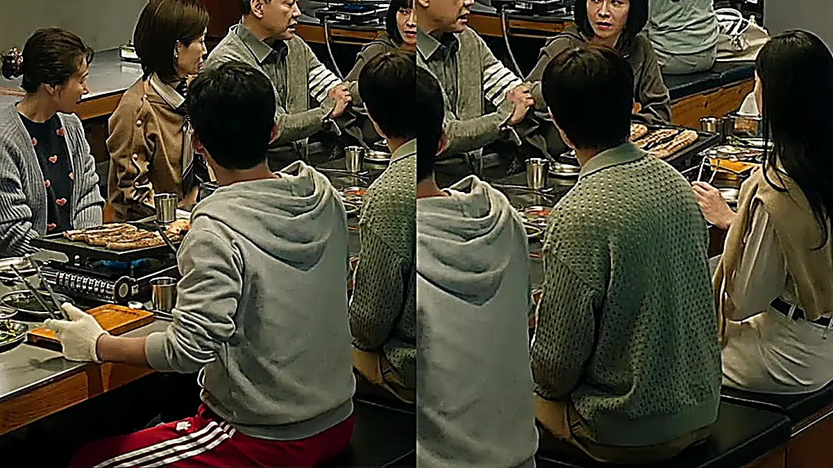 A group of people seated together around a table with a grill sharing a meal