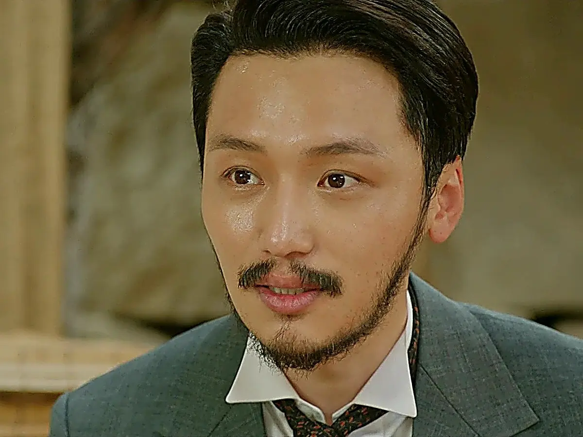 Kim Hui-seong in a grey tailored notch lapel suit jacket and collared dress shirt