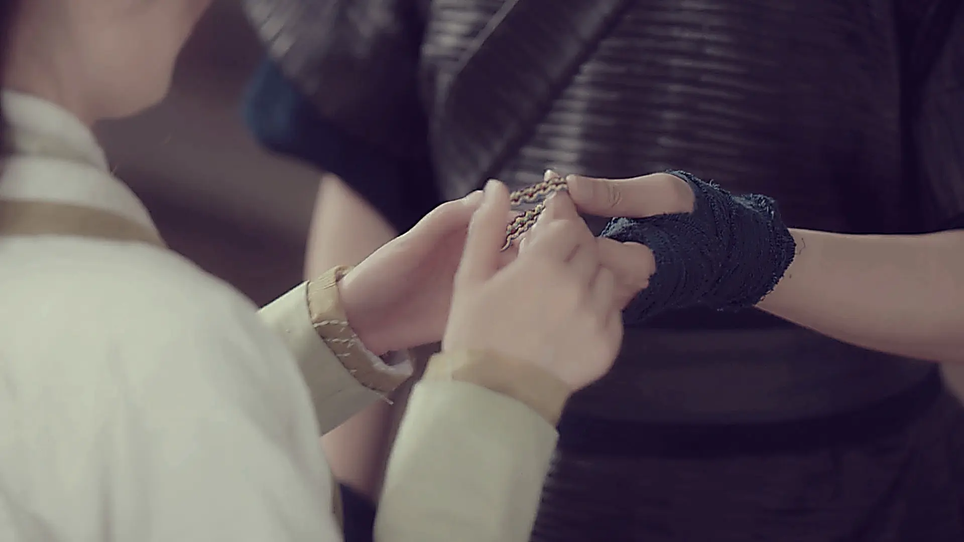 Yuwen Muyuan gifting a woven five-color silk bracelet to Chong Xuezhi
