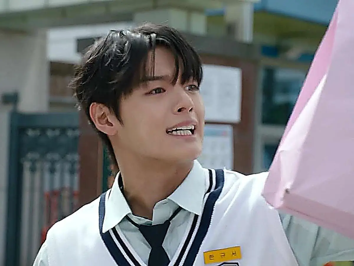 A high school student in a white uniform shirt and dark-trimmed vest angrily holding up a pink bag