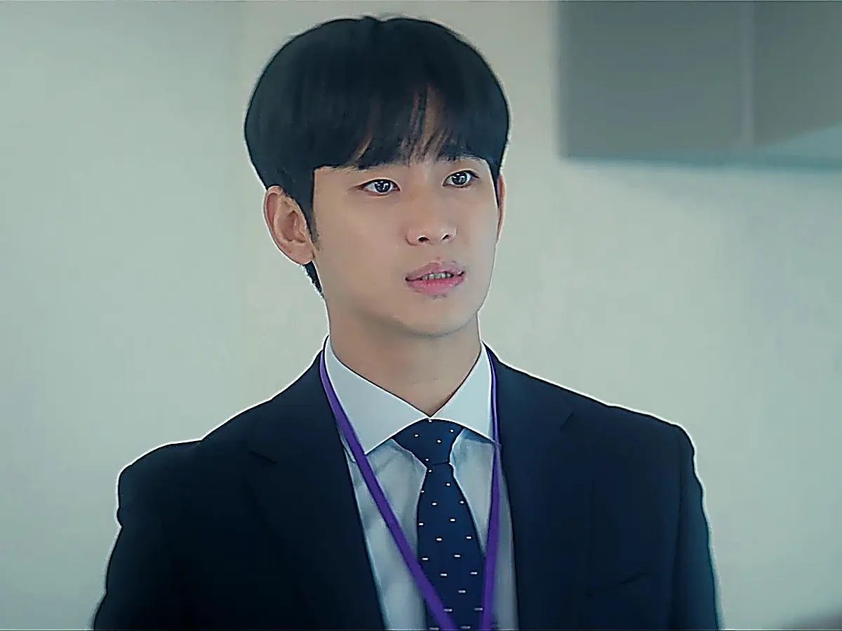 Baek Hyun-woo in a dark navy tailored corporate suit with a crisp white shirt and navy tie